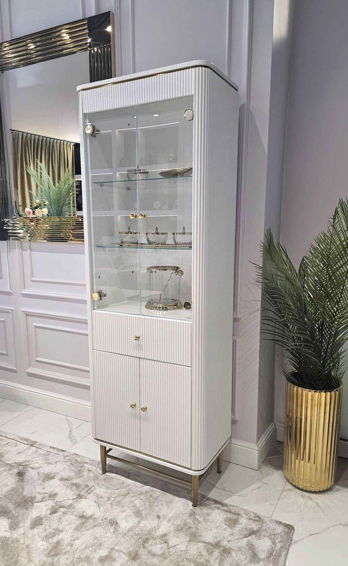 REGAŁ KOMODA Anne wysoka, ryflowany biały korpus, złote metalowe detale, szklana witrynka, nowoczesny styl REGAŁ KOMODA Anne wysoka, ryflowany biały korpus, złote metalowe detale, szklana witrynka, nowoczesny styl