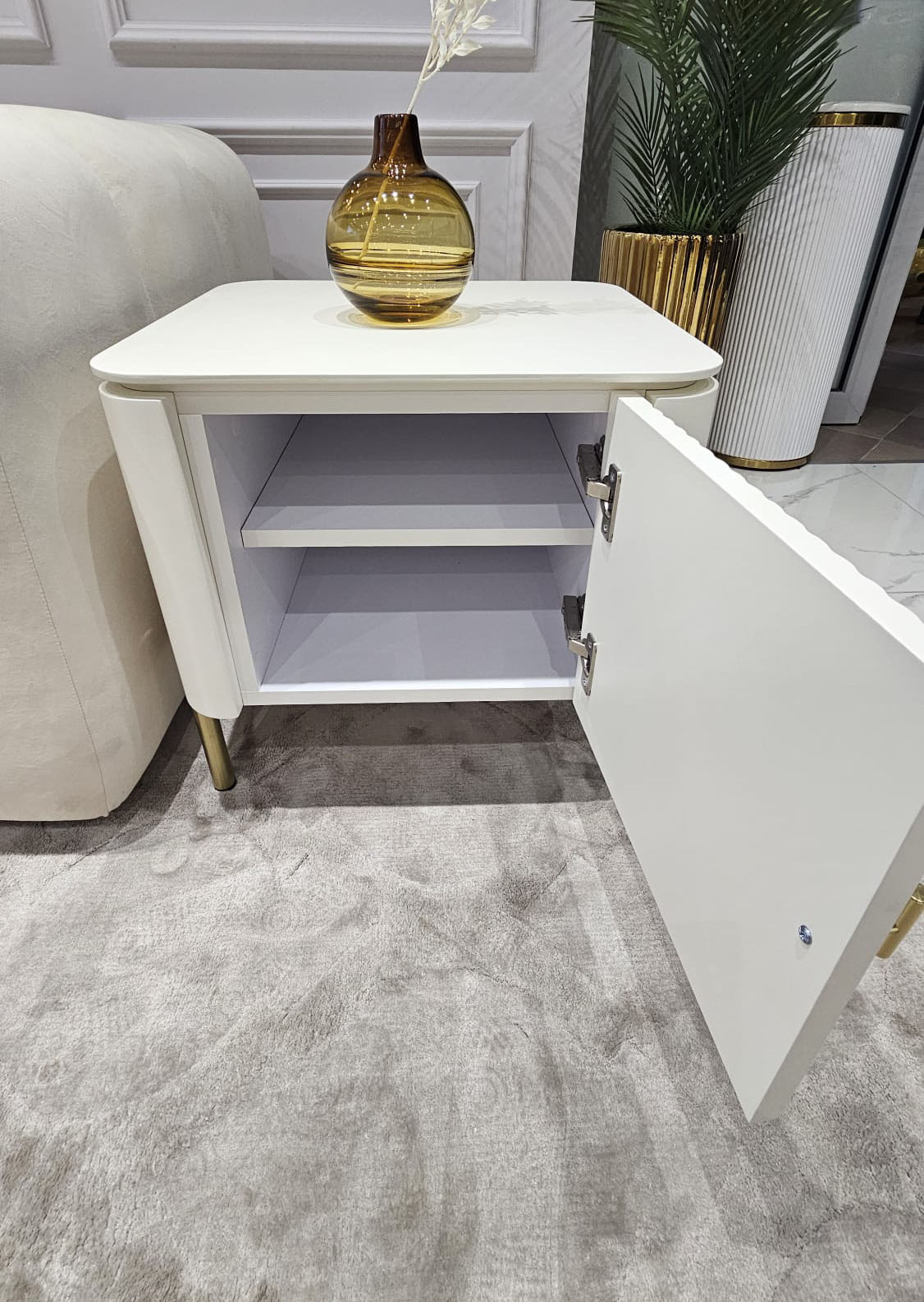 SZAFKA NOCNA Clairmont biało-złota, ryflowany korpus w białym półmatowym odcieniu, metalowe, złote detale, ekskluzywna