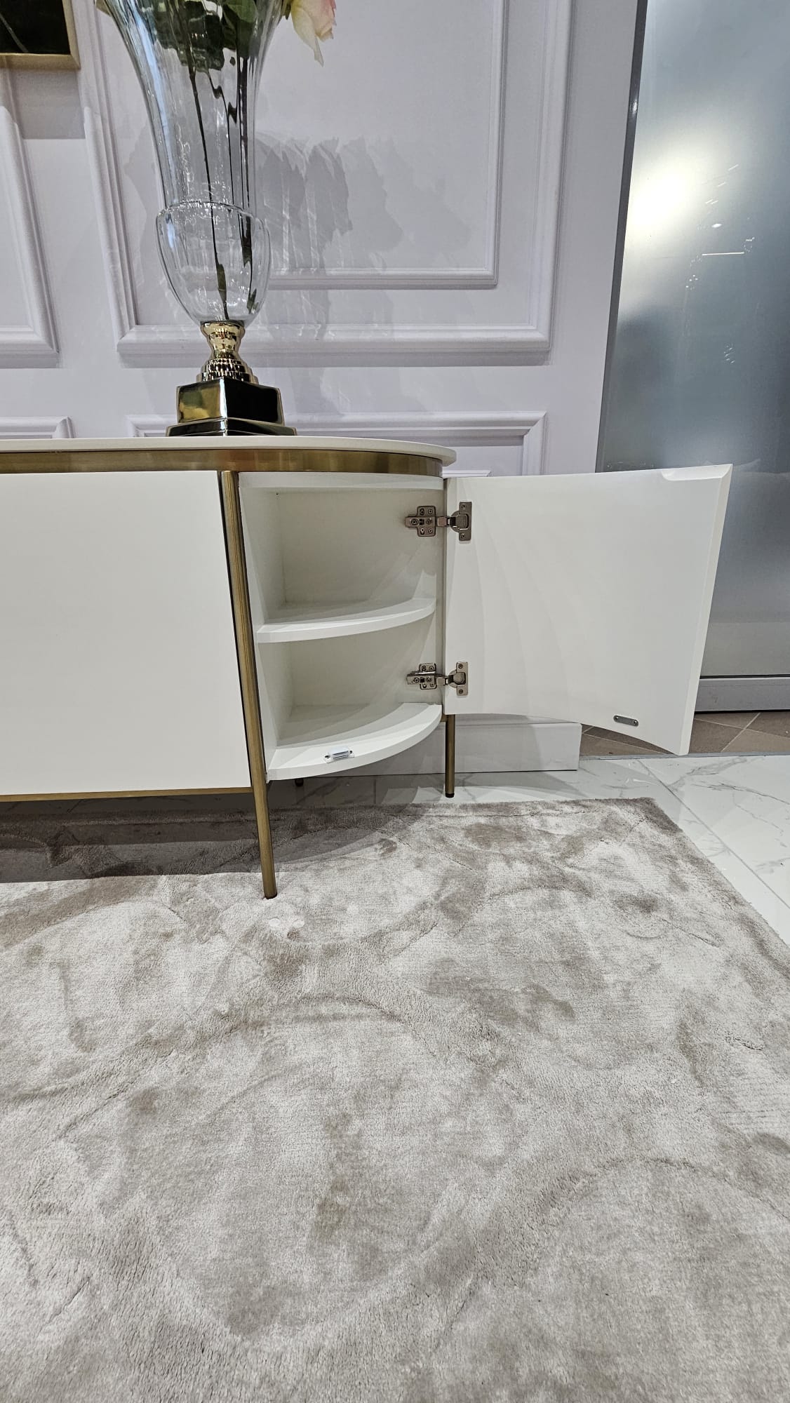 Zdjęcie WhatsApp 2025-09-15 o 13.40.14_b689874e SZAFKA RTV w kolorze ecru z złotytmi, metalowymi dodatkami, blat z marmuru syntetycznego, ryflowane boki, nowoczesny glamour, zaokrąglona