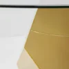 STOLIK KAWOWY Ricchezza na złotej, metalowej podstawie o geometrycznych kształtach, okrągły, szklany blat, wyjątkowy