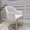 KRZESŁO na złotych błyszczących nogach z pionowym paskiem po środku, welurowa, miękka biała tapicerka, wygodne oparcie oraz podłokietniki, nowoczesny styl, ekskluzywne