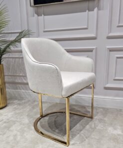 KRZESŁO na złotych błyszczących nogach z pionowym paskiem po środku, welurowa, miękka biała tapicerka, wygodne oparcie oraz podłokietniki, nowoczesny styl, ekskluzywne