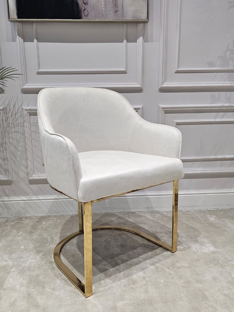 KRZESŁO na złotych błyszczących nogach z pionowym paskiem po środku, welurowa, miękka biała tapicerka, wygodne oparcie oraz podłokietniki, nowoczesny styl
