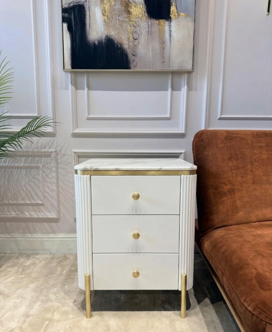 SZAFKA NOCNA Anne Fosco biały korpus z pionowymi ryflowaniami, złote szczotkowane elementy, blat z konglomeratu marmurowego