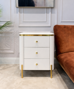 SZAFKA NOCNA Anne biały korpus z pionowymi ryflowaniami, złote błyszczące elementy, blat z konglomeratu marmurowego na nóżkach