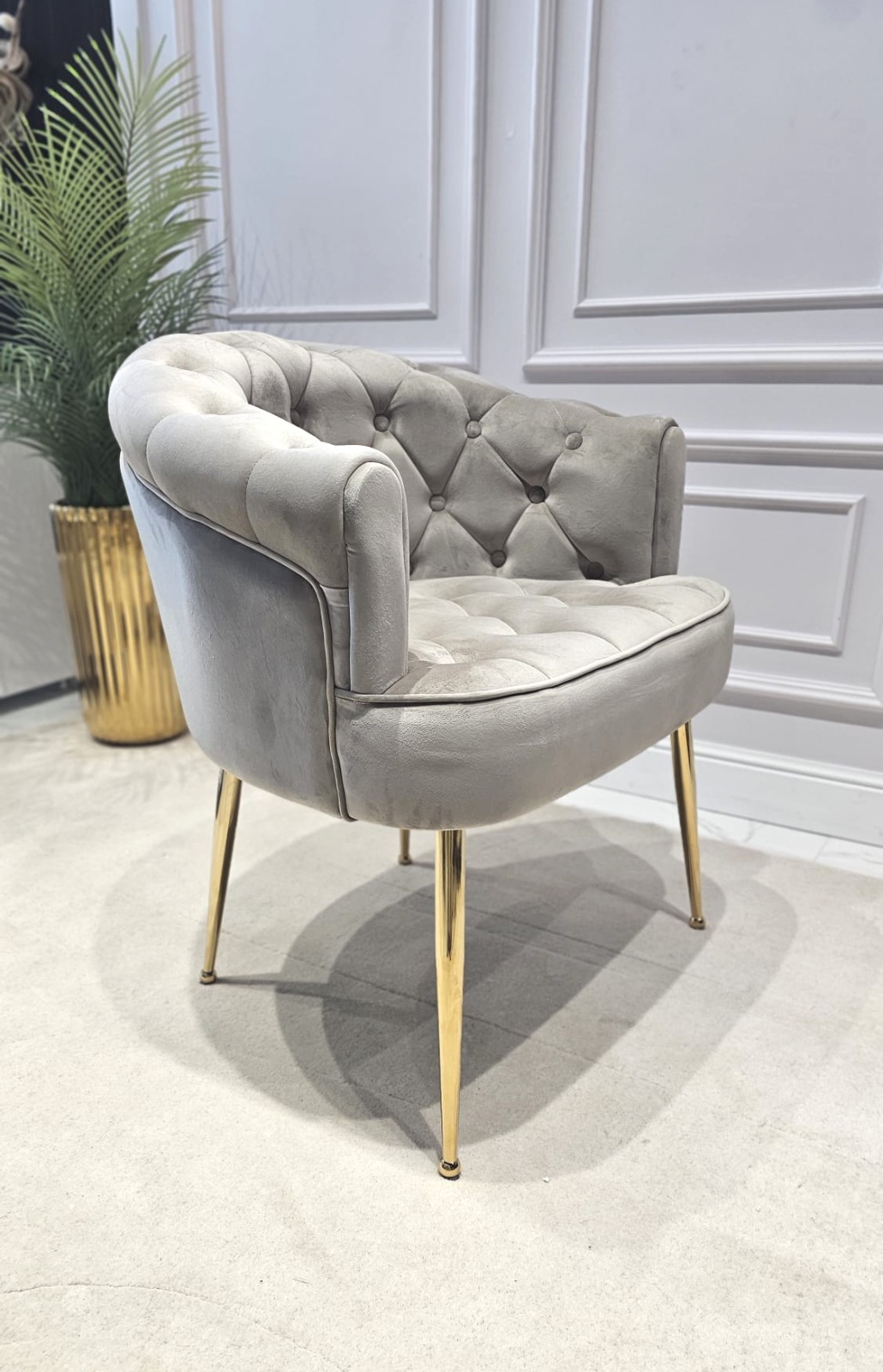 FOTEL z podłokietnikami, siedzisko tapicerowane welwetową tkaniną w kolorze taupe z eleganckimi pikowaniami, metalowe nogi w złotym błyszczącym wykończeniu, do salonu