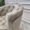 FOTEL z podłokietnikami, siedzisko tapicerowane welwetową tkaniną w kolorze taupe z eleganckimi pikowaniami, metalowe nogi w złotym błyszczącym wykończeniu, ekskluzywny