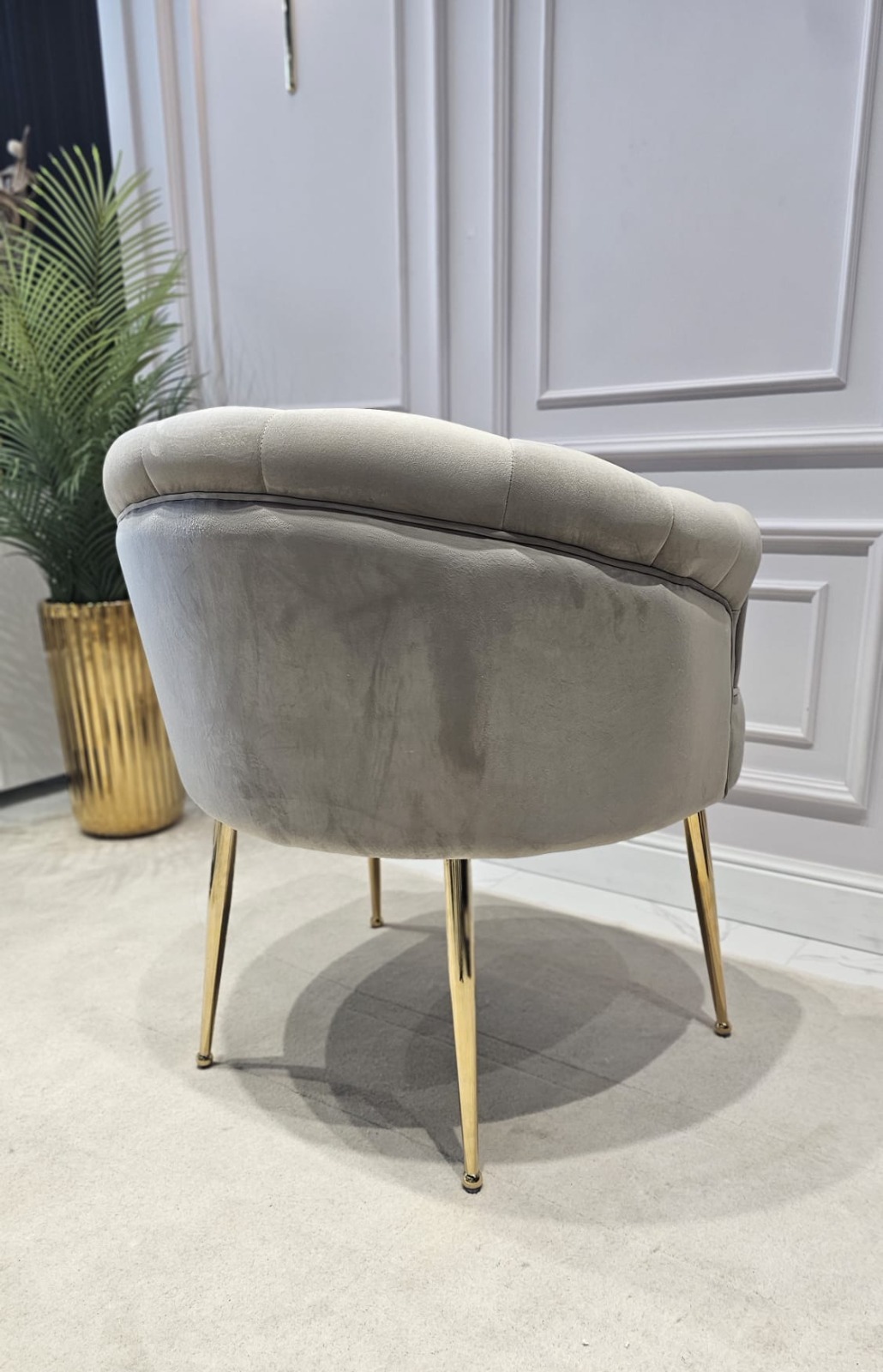 FOTEL z podłokietnikami, siedzisko tapicerowane welwetową tkaniną w kolorze taupe z eleganckimi pikowaniami, metalowe nogi w złotym błyszczącym wykończeniu, wyjątkowy