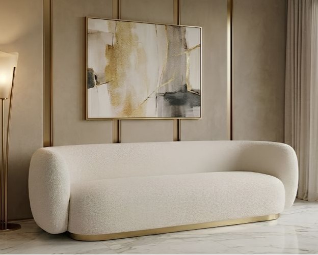 SOFA o nowoczesnych, zaoblonych kształtach, delikatny, złoty pasek u dołu, jasnobeżowa, aksamitna tkanina typu boucle